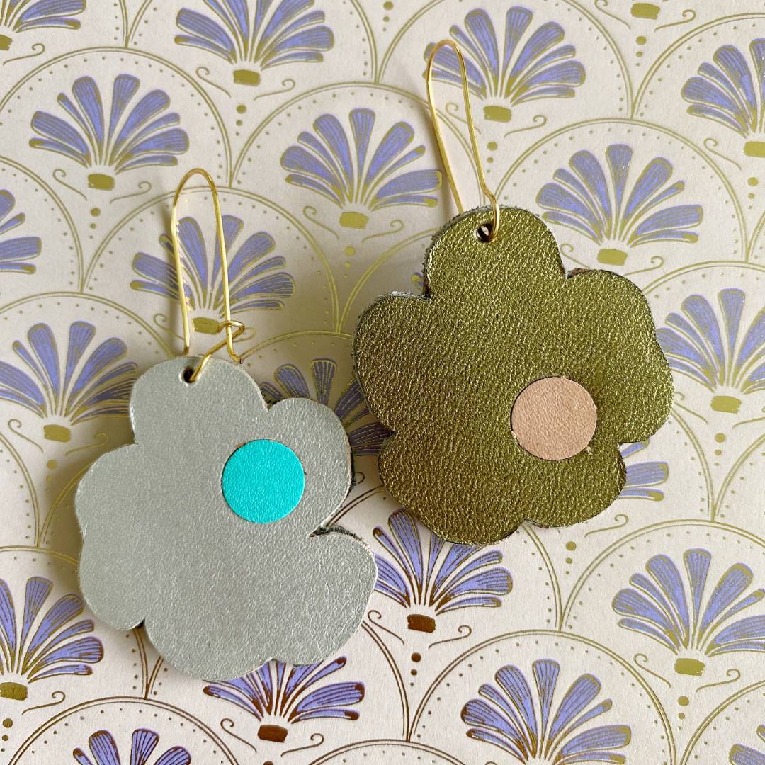 Aretes de cuero recuperado reversibles en forma de margarita. Diseño costarricense. Joyería artesanal contemporánea sostenible. Joyería de autor.