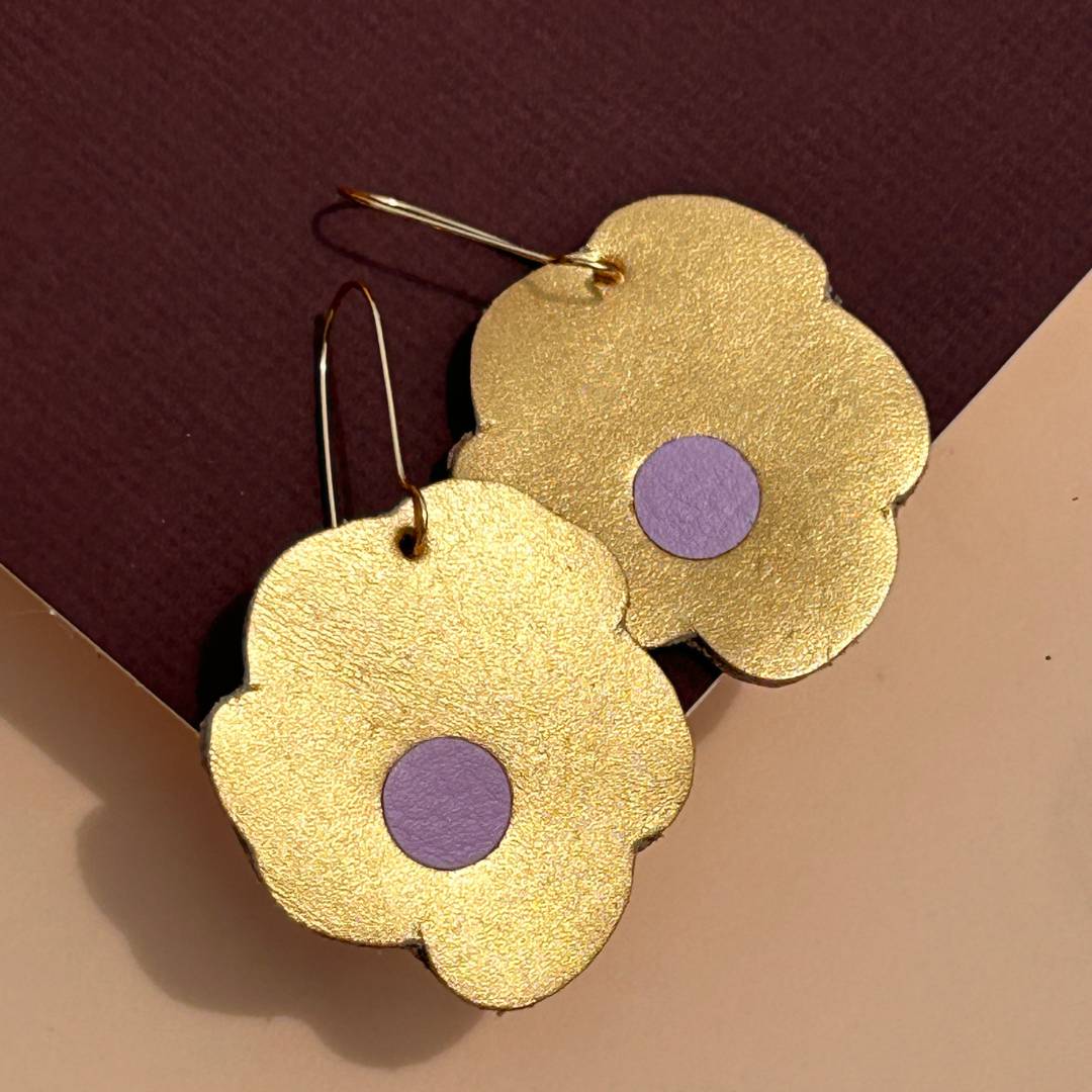 Aretes de cuero recuperado reversibles en forma de margarita. Diseño costarricense. Joyería artesanal contemporánea sostenible. Joyería de autor. 