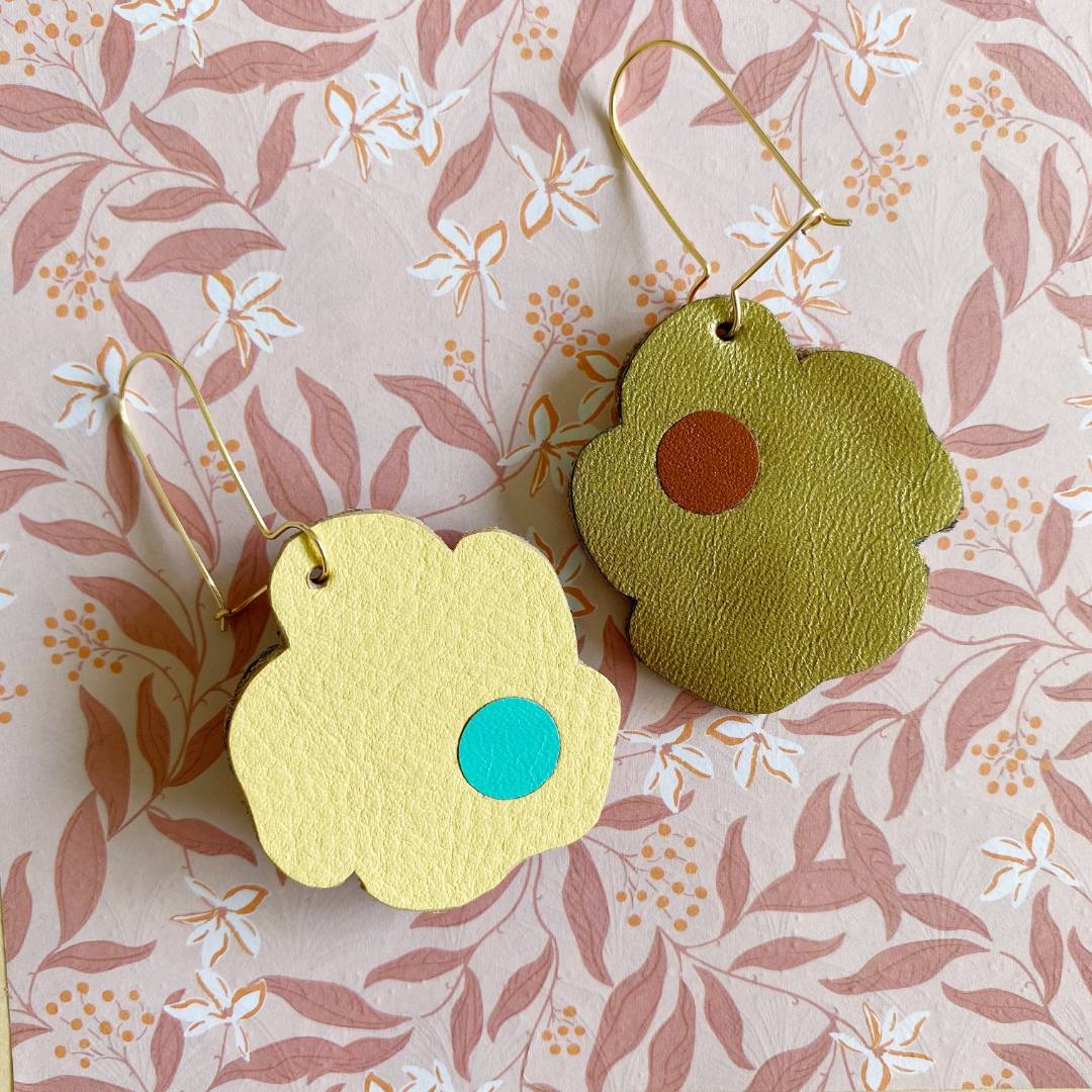 Aretes de cuero recuperado reversibles en forma de margarita. Diseño costarricense. Joyería artesanal contemporánea sostenible. Joyería de autor. 