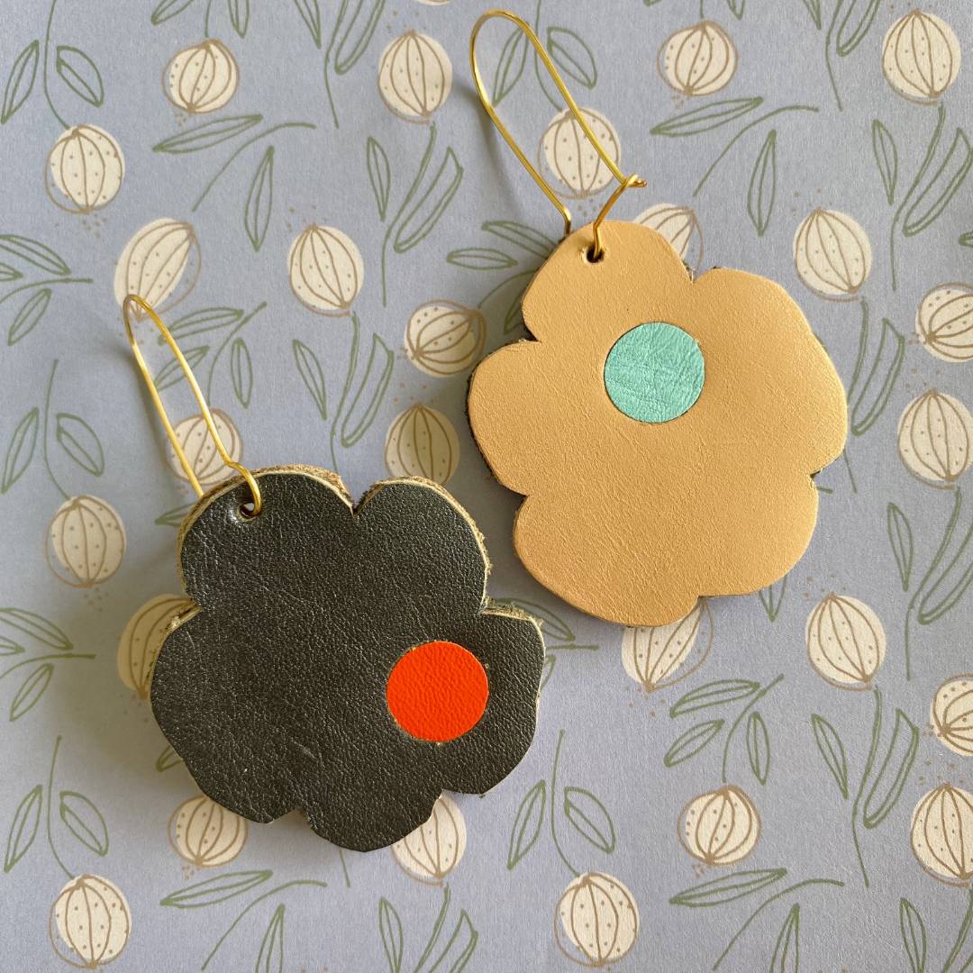 Aretes de cuero recuperado reversibles en forma de margarita. Diseño costarricense. Joyería artesanal contemporánea sostenible. Joyería de autor. 