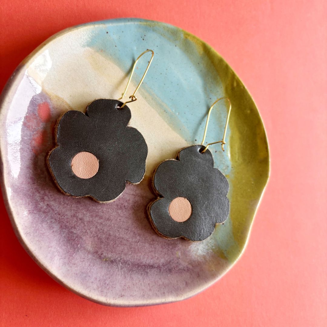 Aretes de cuero recuperado reversibles en forma de margarita. Diseño costarricense. Joyería artesanal contemporánea sostenible. Joyería de autor. Alta artesanía. Diseño artesanal. 