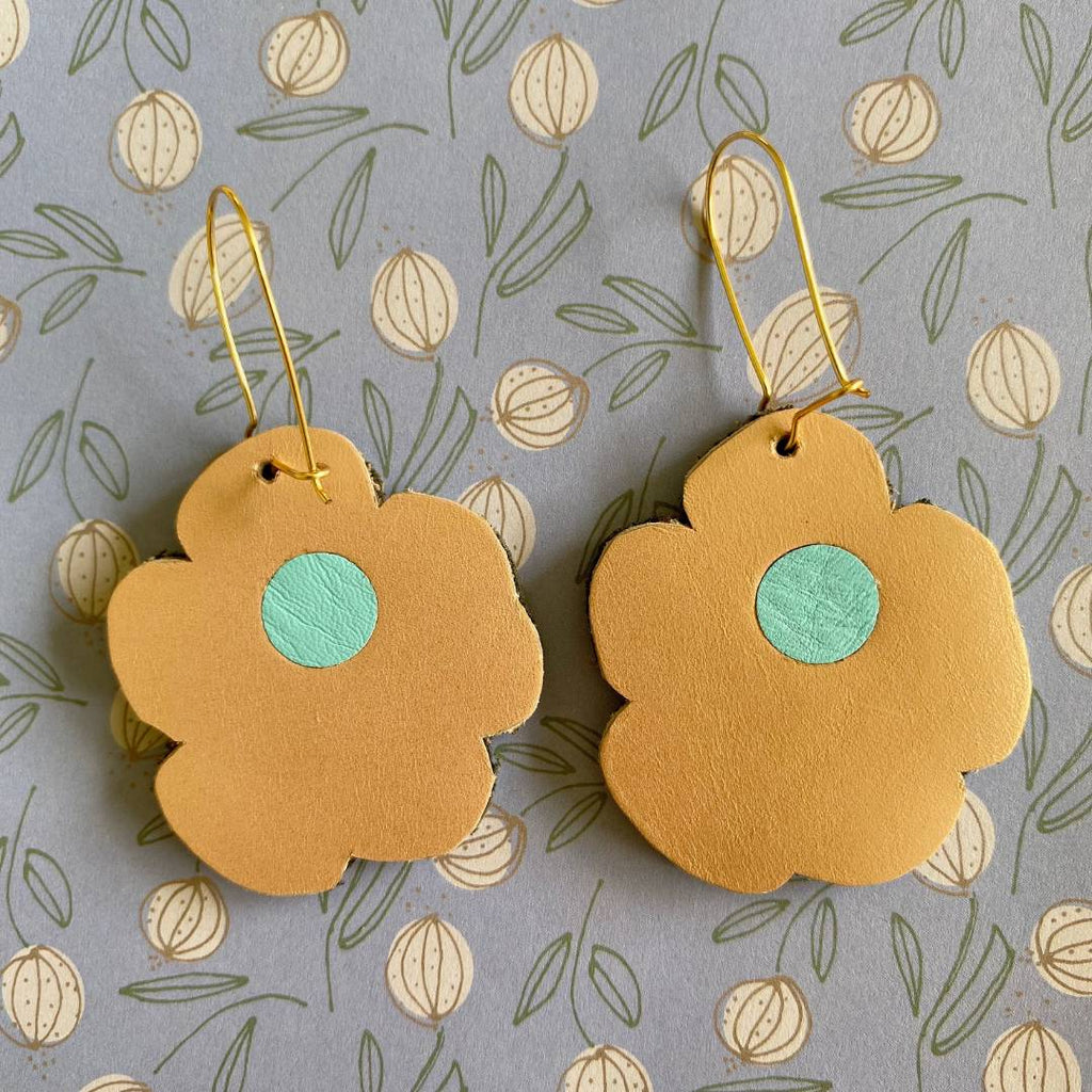 Aretes de cuero recuperado reversibles en forma de margarita. Diseño costarricense. Joyería artesanal contemporánea sostenible. Joyería de autor. 