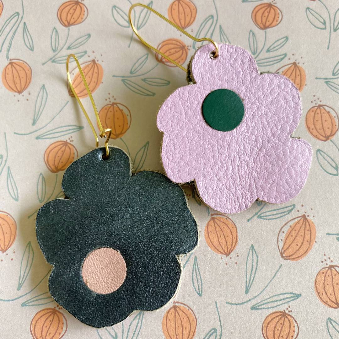 Aretes de cuero recuperado reversibles en forma de margarita. Diseño costarricense. Joyería artesanal contemporánea sostenible. Joyería de autor. 