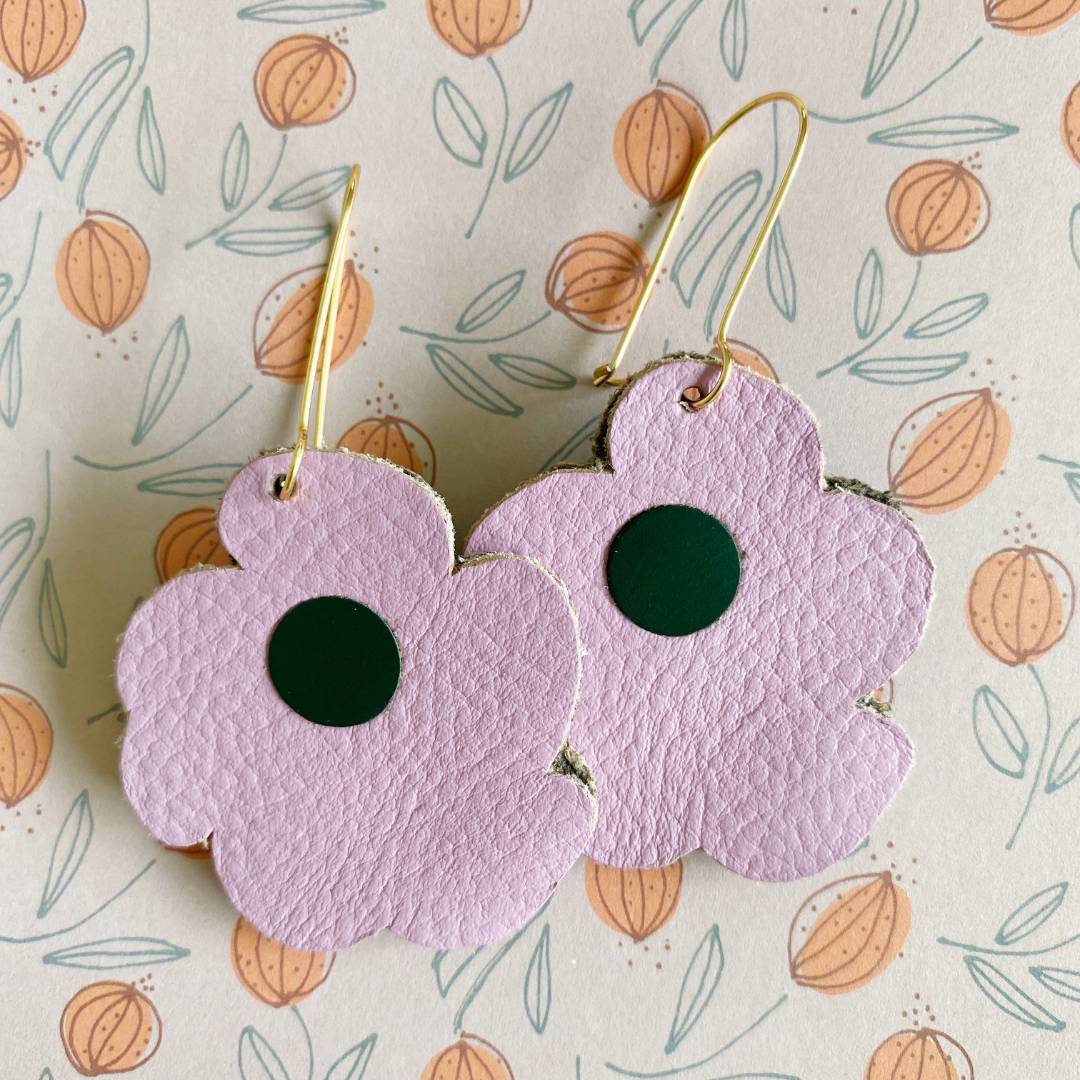 Aretes de cuero recuperado reversibles en forma de margarita. Diseño costarricense. Joyería artesanal contemporánea sostenible. Joyería de autor. 