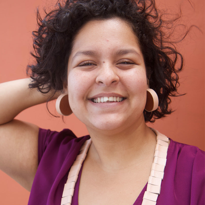 Mujer usando los aretes de madera con cuero salmón