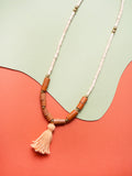 Collar largo de piezas de madera natural con rollitos en cuero color miel, bolitas doradas de acero inoxidable y rollito de hilos de algodón en naranja teñidos con tintes naturales de semillas de achiote