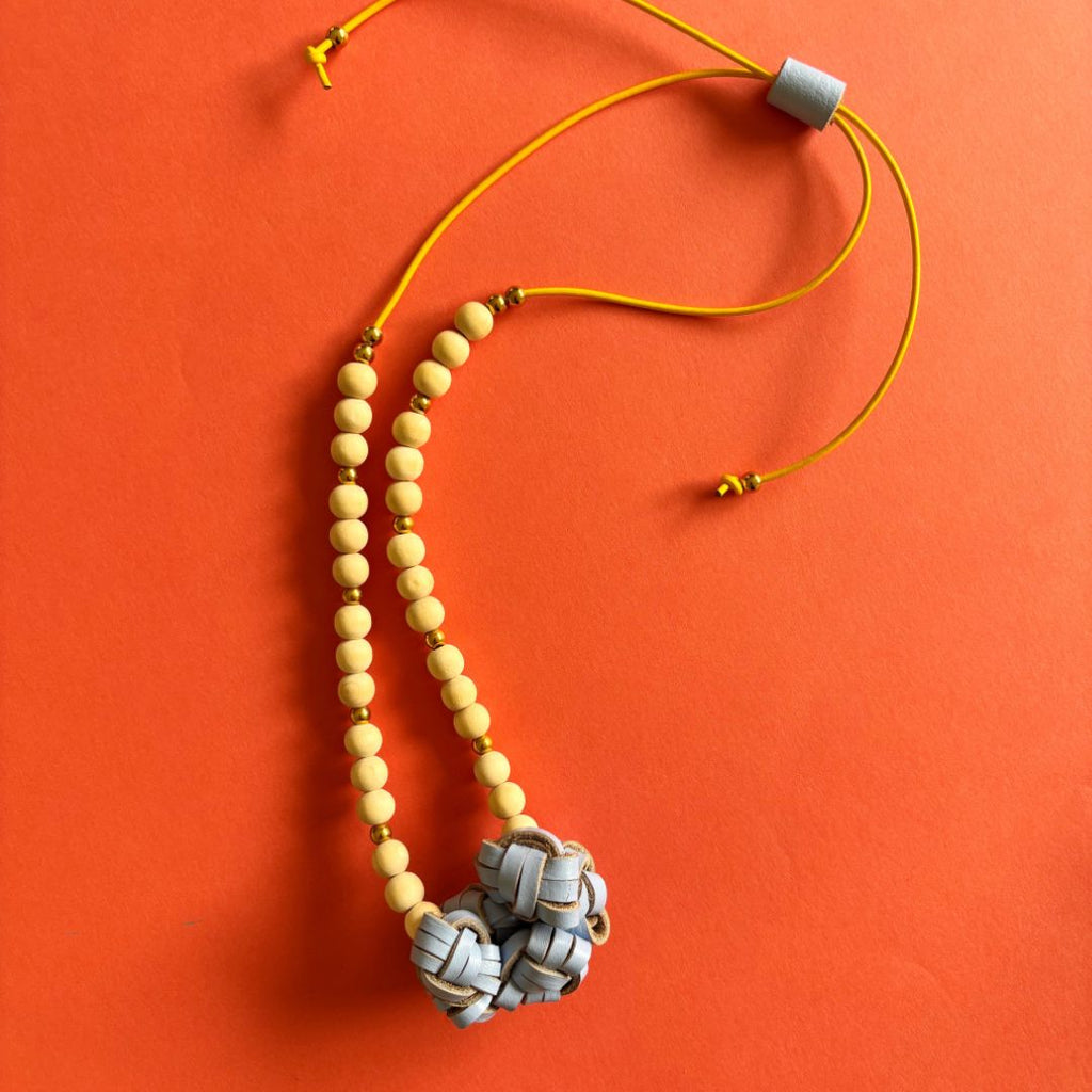 Collar Nudos de cuero recuperado color celeste y bolitas de madera natural. Joyería artesanal sostenible de Costa Rica. Diseño local. 