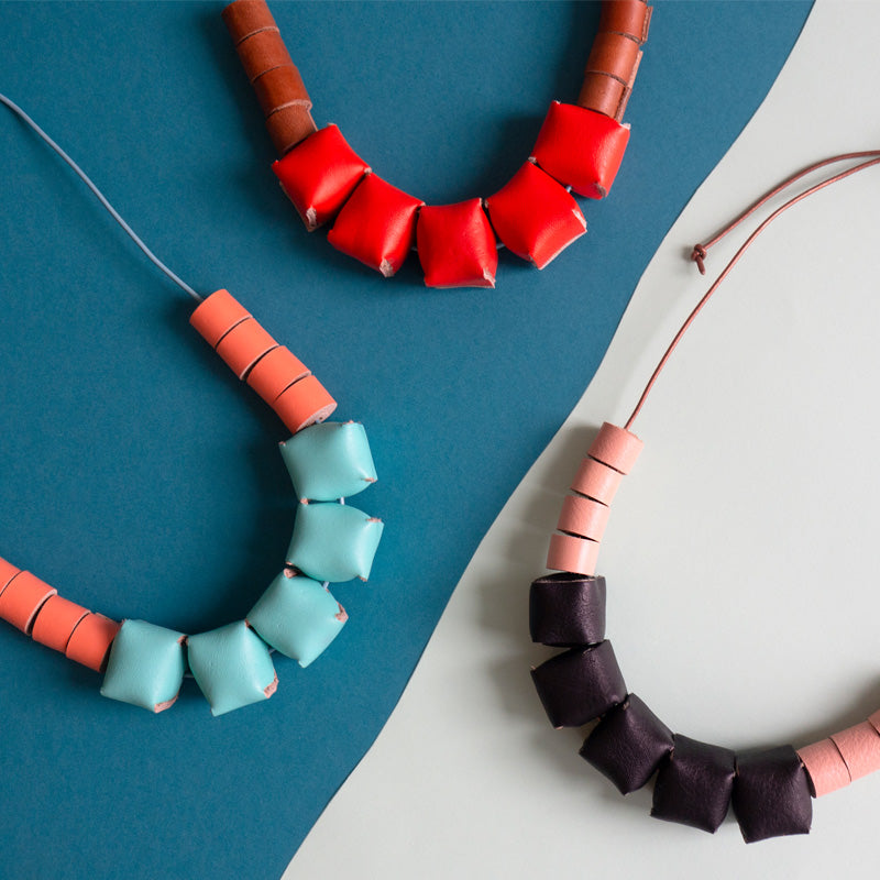 Tres collares cubos sobre fondo de color azul con celeste