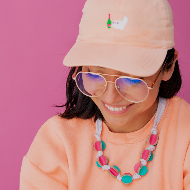 Mujer usando el collar caleidoscopio sobre un abrigo naranja claro