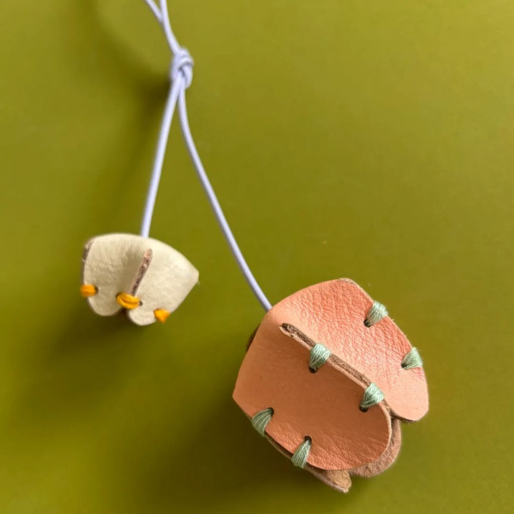 Detalle de flores de cuero de 4 cm y 2.5 cm con costuras artesanales teñidas naturalmente