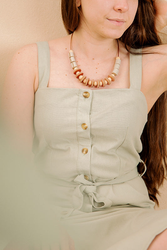 Mujer usando el collar de cuero vainilla a la altura del pecho con jumpsuit vede olivo