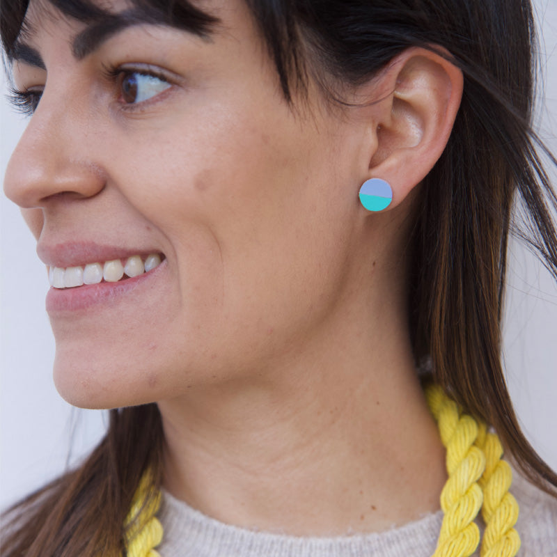 Mujer sonriente usando un par de aretes de cuero