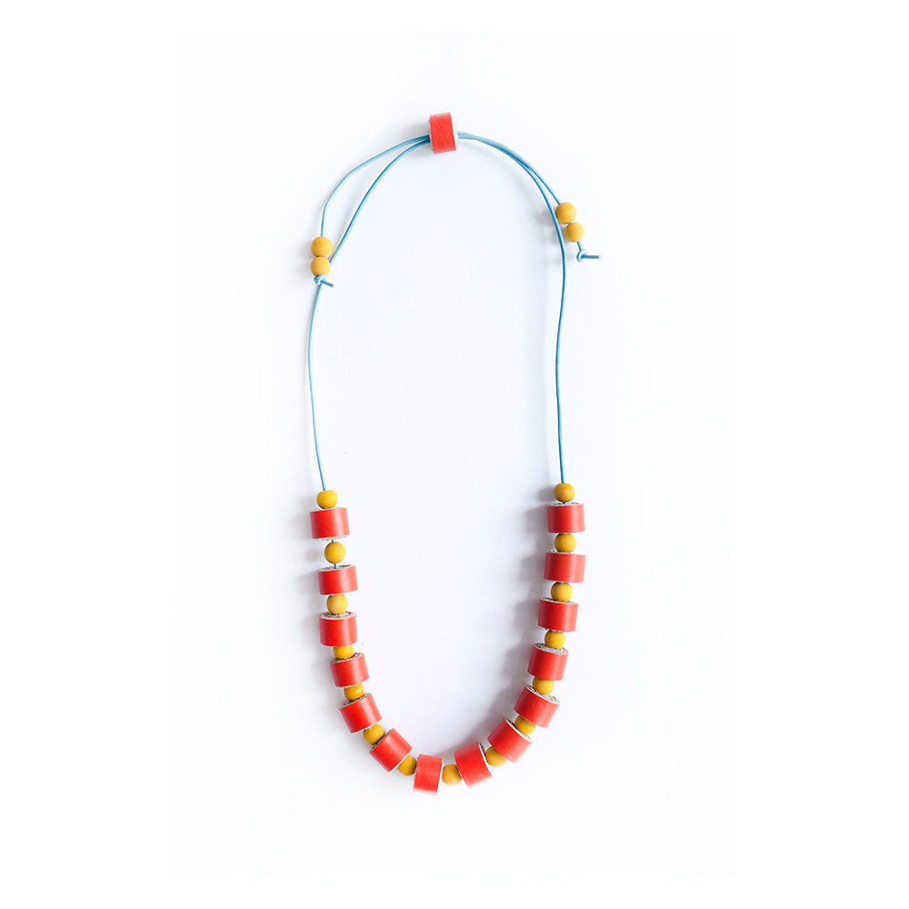 Collar completo hecho con rollitos de cuero color naranja con bolitas de madera amarillas teñidas con tinte natural extraído de la cúrcuma, cierre ajustable, cordón de cuero celeste