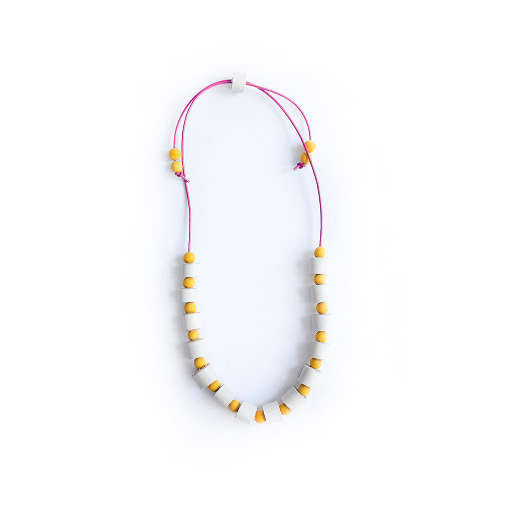 Collar completo hecho con rollitos de cuero color vainilla con bolitas de madera amarillas teñidas con tinte natural extraído de la cúrcuma, cierre ajustable, cordón de cuero vino