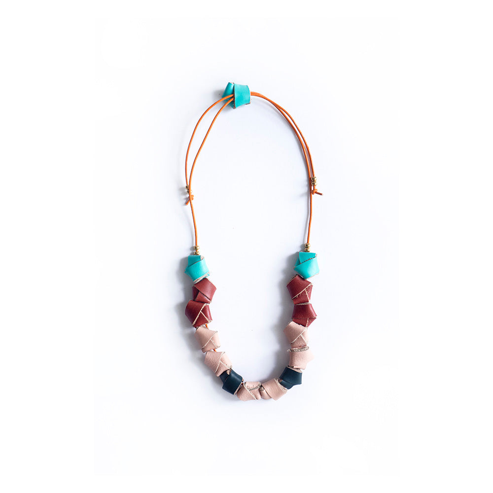 Collar completo hecho con nudos en cuero de colores turquesa, rojo, salmón y verde inglés, cierre ajustable para usarlo corto o largo con cordón de cuero naranja y bolitas doradas de acero inoxidable