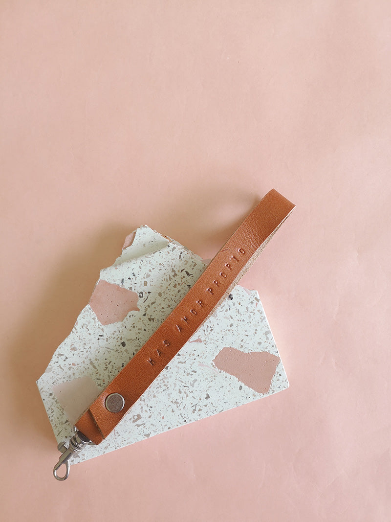 Llavero de cuero en color miel con la frase Más amor propio estampada a mano