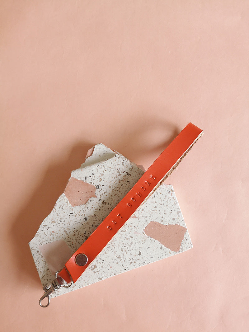 Llavero de cuero en color naranja con la frase Soy Bondad estampada a mano